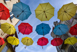 CITY LANDSCAPE - Tenement houses and colorful umbrellas against the blue sky