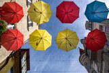 CITY LANDSCAPE - Tenement houses and colorful umbrellas against the blue sky