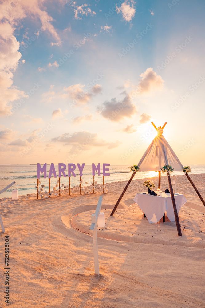 Fototapeta premium Love couple proposal romantic proposal on paradise beach in island Maldives. Panoramic sunset of Marry Me sign sandy beach background. Romance colorful sky sea. Marriage honeymoon tropical destination