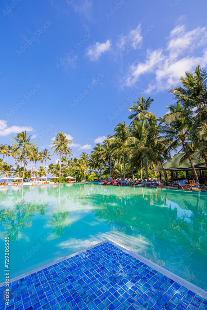 Outdoor tourism wellbeing landscape. Luxury beach resort spa swimming pool leisure beach chairs loungers under umbrellas with palm trees blue sky. Summer happy travel recreation vacation background