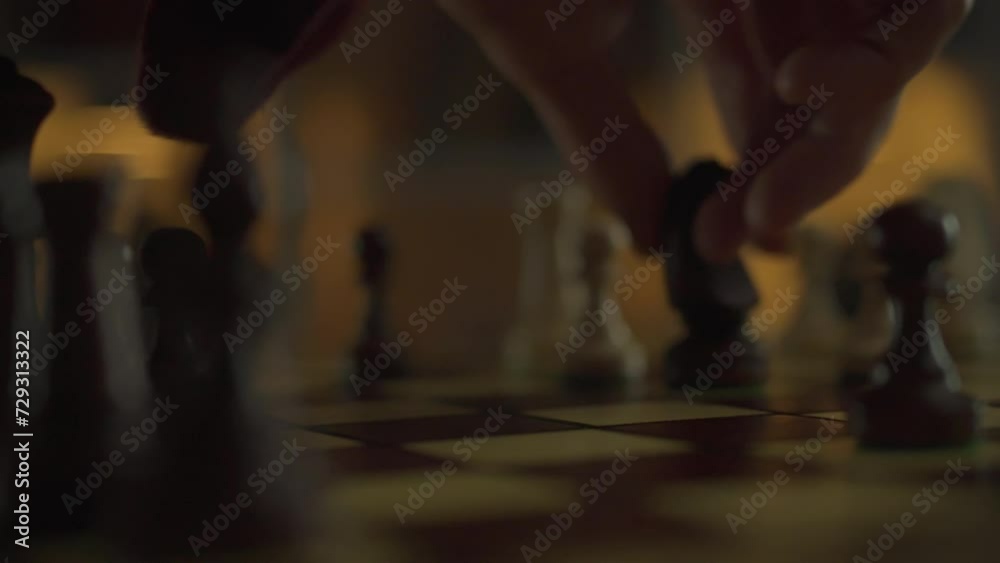 A piece in chess game is executed with confidence by an experienced player, each move as if it were part of a cinematic scene. A battle between two professionals takes place in an authentic chess hall A piece in chess game is executed with confidence by an experienced player, each move as if it were part of a cinematic scene. A battle between two professionals takes place in an authentic chess hall