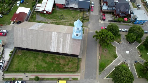 Aerial Drone Rotate Above Patrimonial Chilean Church in Dalcahue Chiloé Island around Streets and Local Neighborhood photo