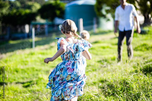 Happy girl running through long grass to see her father photo