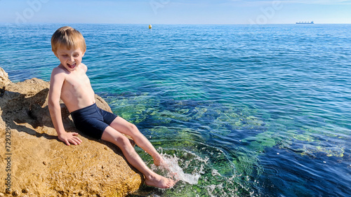 Happy kid at the sea having fun and splashing water in summer © Aloshin Evgeniy