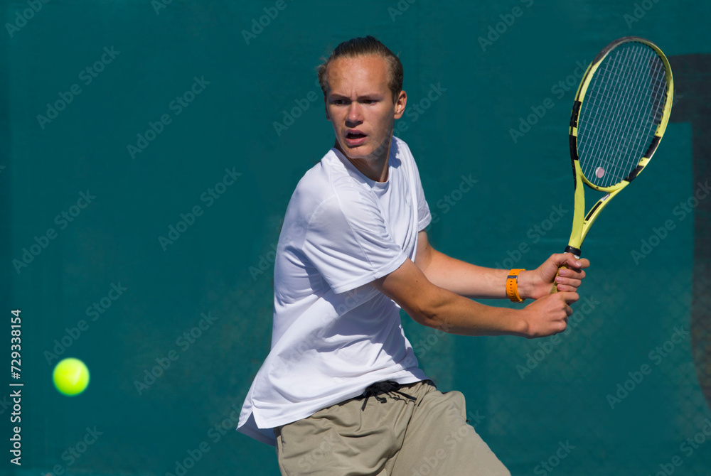 Tennis player playing tennis on a hard court on a bright sunny day