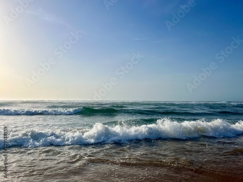 Seashore background, sea horizon, sea foam at the sandy coast