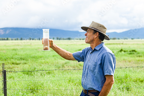 Farmer checking rain in bureau of meteorology rain gauge photo
