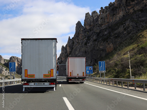 Konstfotografi Behind overtaking lorries on steep two-lane motorway through mountains blocking