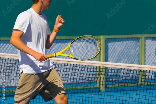Tennis player playing tennis on a hard court on a bright sunny day 