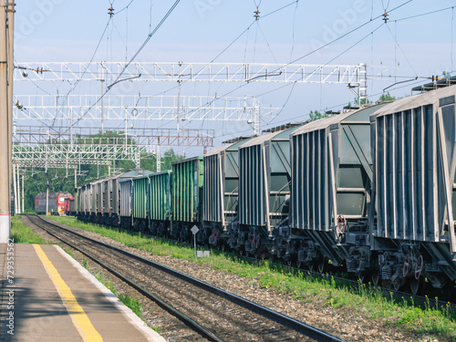 The railway platform at the station. A place for passengers to board the train. Railway tracks for railway transport. Freight cars at the station. Transportation of goods by rail. © Eduard Belkin