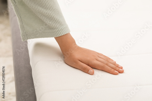 Woman touching white soft mattress indoors, closeup © New Africa