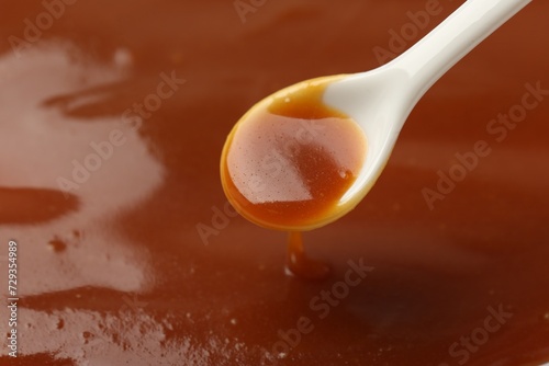 Taking tasty salted caramel with spoon, closeup. Space for text