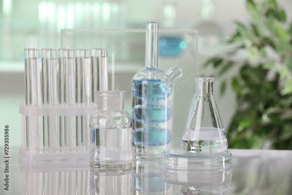 Laboratory analysis. Different glassware with liquid on white table indoors Laboratory analysis. Different glassware with liquid on white table indoors