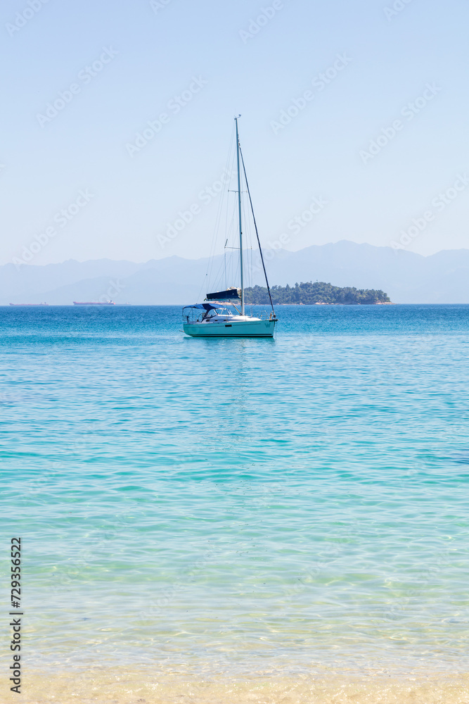 Sailboat anchored at Dentista beach, a beautiful and paradisiacal beach located in Angra dos Reis, Rio de Janeiro, Brazil.