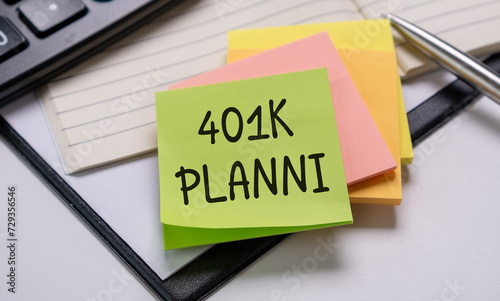 Reminder note about 401K planning on notepad with calculator and pen
