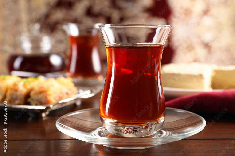 Traditional Turkish tea in glass on wooden table, closeup Traditional Turkish tea in glass on wooden table, closeup