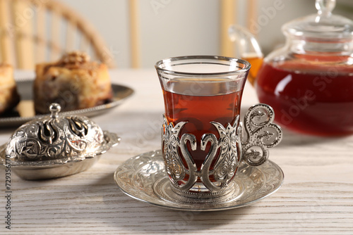 Traditional Turkish tea and sweets served in vintage tea set on white wooden table