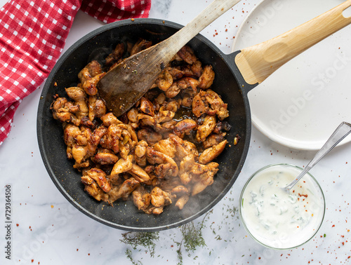 Homemade gyros, greek meat dish in a frying pan on kitchen table