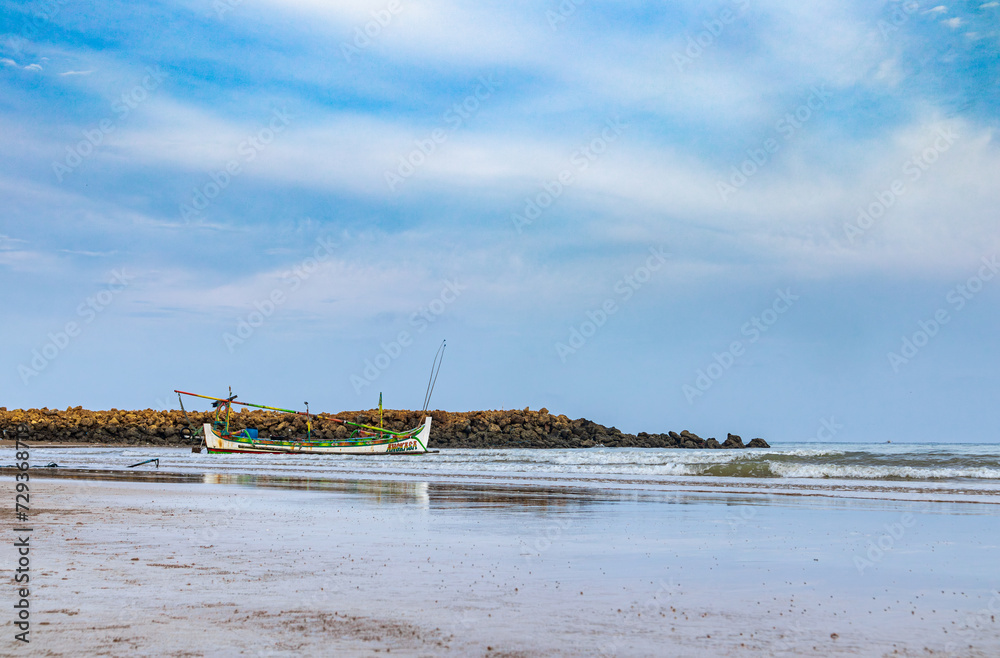 View of a clear sky with traditional fishing boats floating on the coast of Sumenep, Madura island, Indonesia.