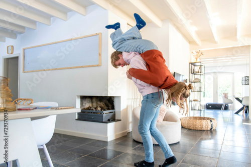 Brother and sister play fighting in their modern living room bright and aery  photo