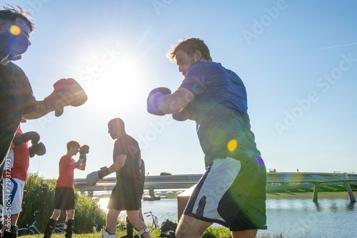 Young men keeping fit by kickboxing. Group of guys healthy and fit photo