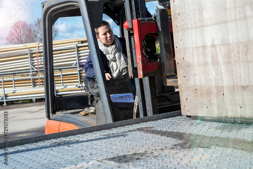 Female farm worker driving a forklift truck photo