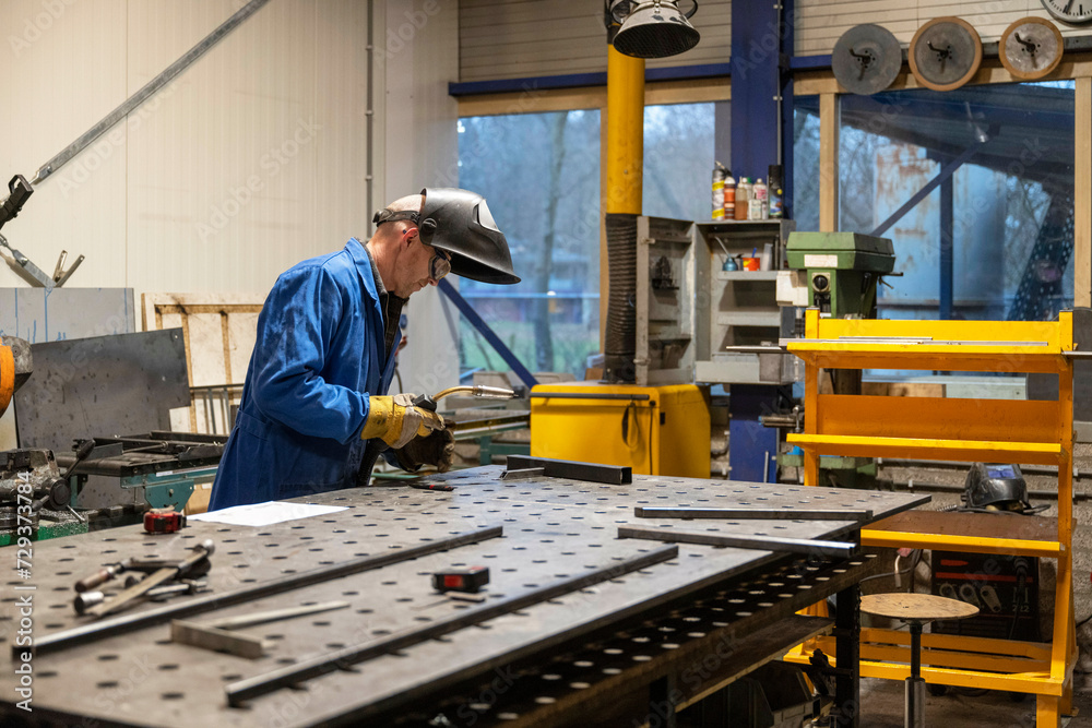 Man welding metal together for a client Man welding metal together for a client