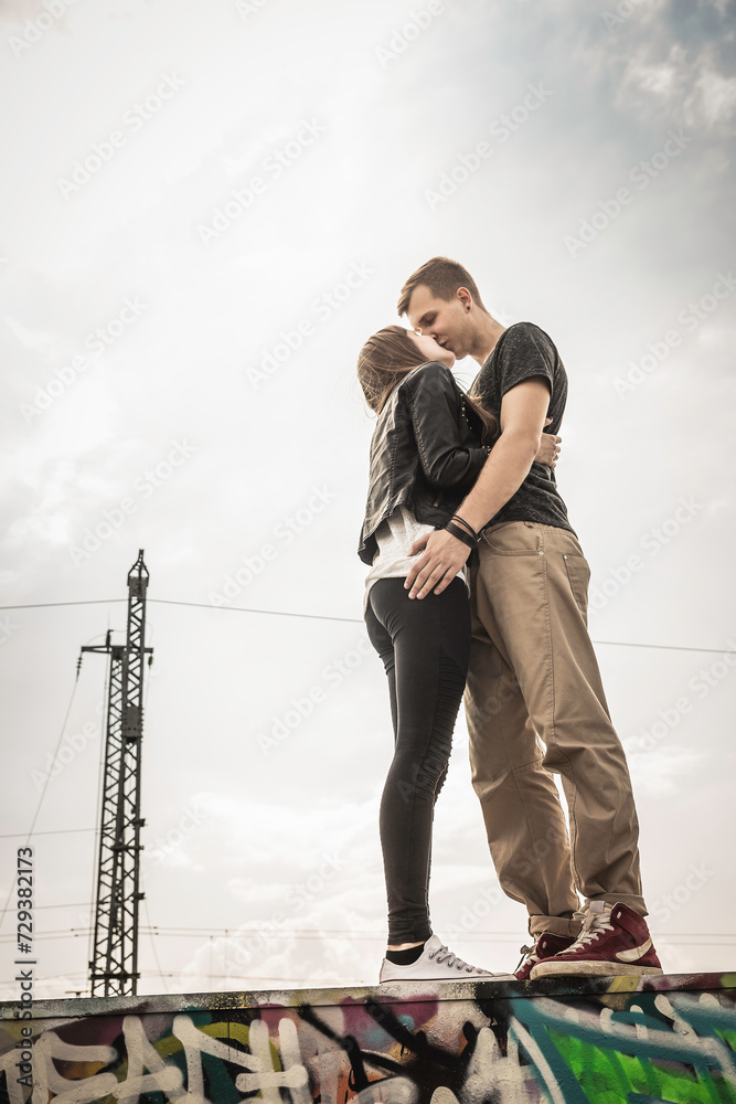 Portrait of young couple kissing each other in an industrial urban area. Munich, Germany Portrait of young couple kissing each other in an industrial urban area. Munich, Germany