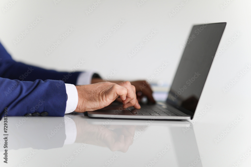 Close-up of a businessman's hands typing on a laptop keyboard Close-up of a businessman's hands typing on a laptop keyboard