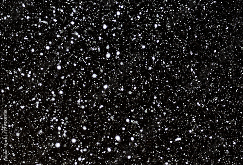 黒い背景に降雪。冬のイメージ背景。