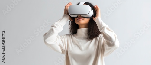 Young woman using virtual reality headset on plain background © Voilla