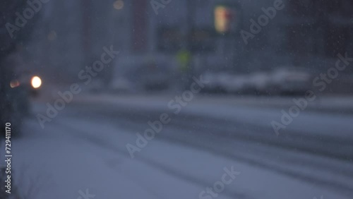 Truck driving down a dark street in a snowstorm. Purposely defocused photo