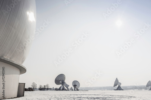 Uplink satellite station in winter landscape with snow and blue skies. 