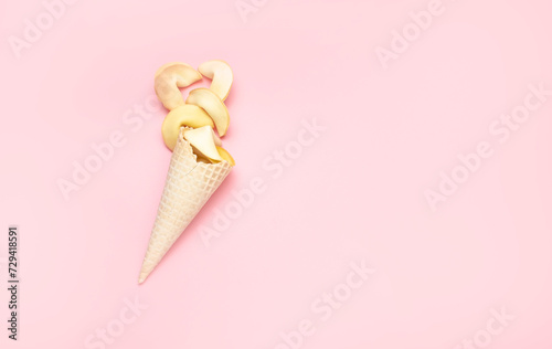 Pink background with cookies. Fortune cookies and ice cream cone on a pink background.