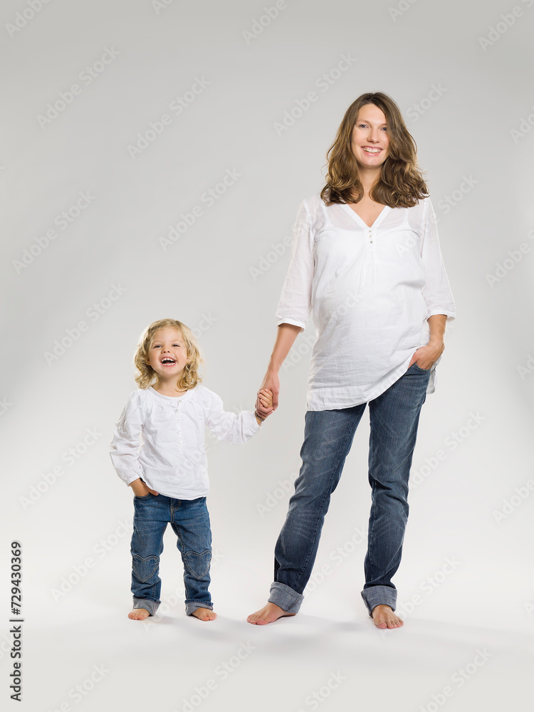 studio shot of pregnant mother and daughter