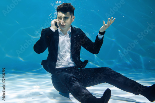 Schilderij op canvas Crazy businessman talking on the phone while submerged underwater