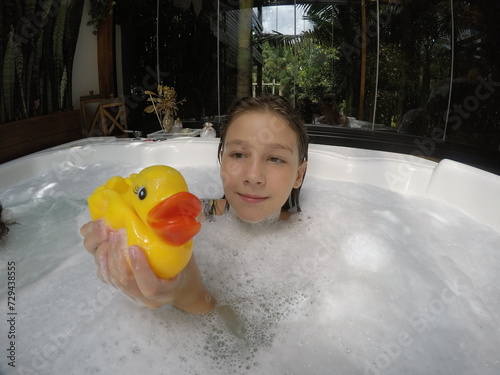 criança menina sorridente brincando em banheira de espuma  photo