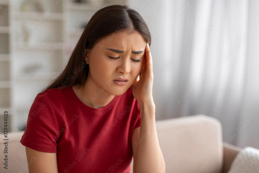 Asian woman with severe headache feeling unwell at home Asian woman with severe headache feeling unwell at home