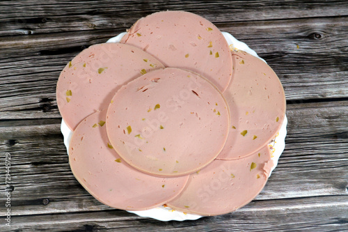 Lunch meats, cold cuts, luncheon cooked sliced cold delicatessens deli chicken meats, precooked or cured meats that are sliced and served cold made of chicken breast and loaf with cuts of olive in it