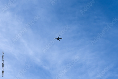 London, UK, 25 January 2024: Airplane flying in the blue sky among clouds and sunlight