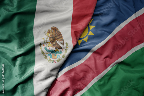 big waving national colorful flag of namibia and national flag of mexico .