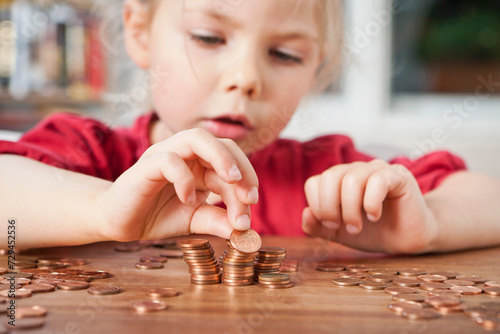 Young girl counting pennies on the table. photo