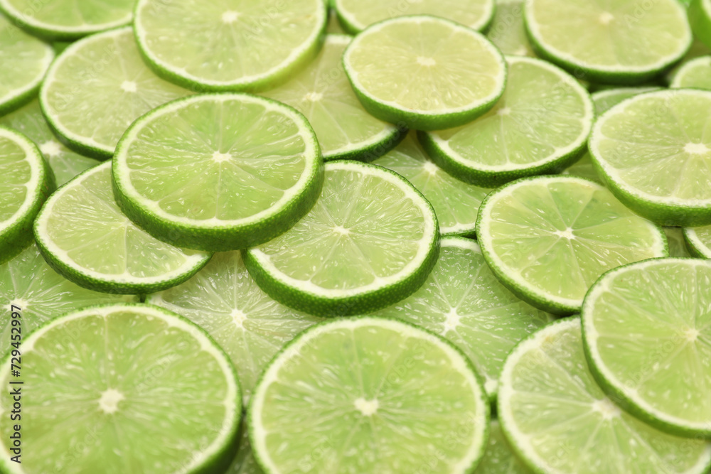 Many juicy lime slices as background, above view