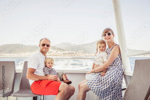 Portrait of family of four while traveling on a ferry in the Mediterranean Sea. Korsika, Italy photo