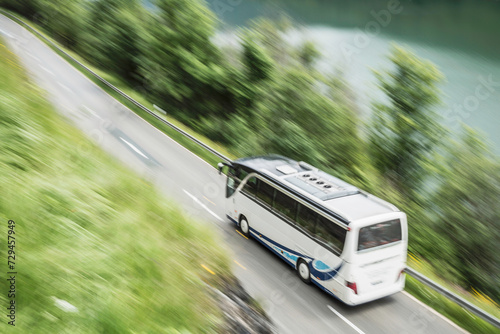 View from above of street with bus and lake in background.