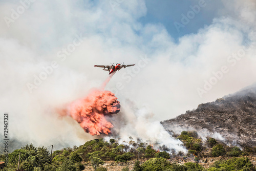 Plane dropping flame retardant, ammonia sulfate, onto wild fire in the mountains of Corsica.