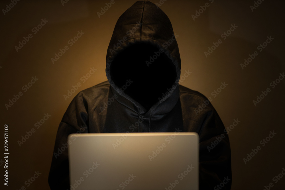 Male hacker in dark room using laptop internet hacking Male hacker in dark room using laptop internet hacking