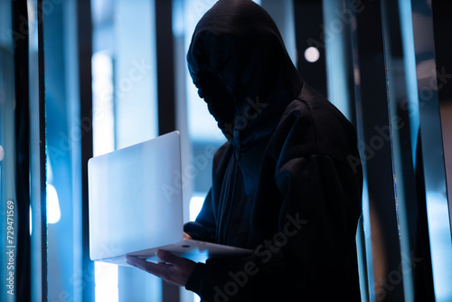 Fototapeta Naklejka Na Ścianę i Meble -  Male hacker in dark room using laptop internet hacking