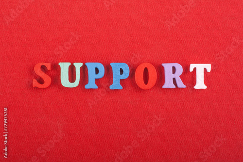 SUPPORT word on red background composed from colorful abc alphabet block wooden letters, copy space for ad text. Learning english concept.