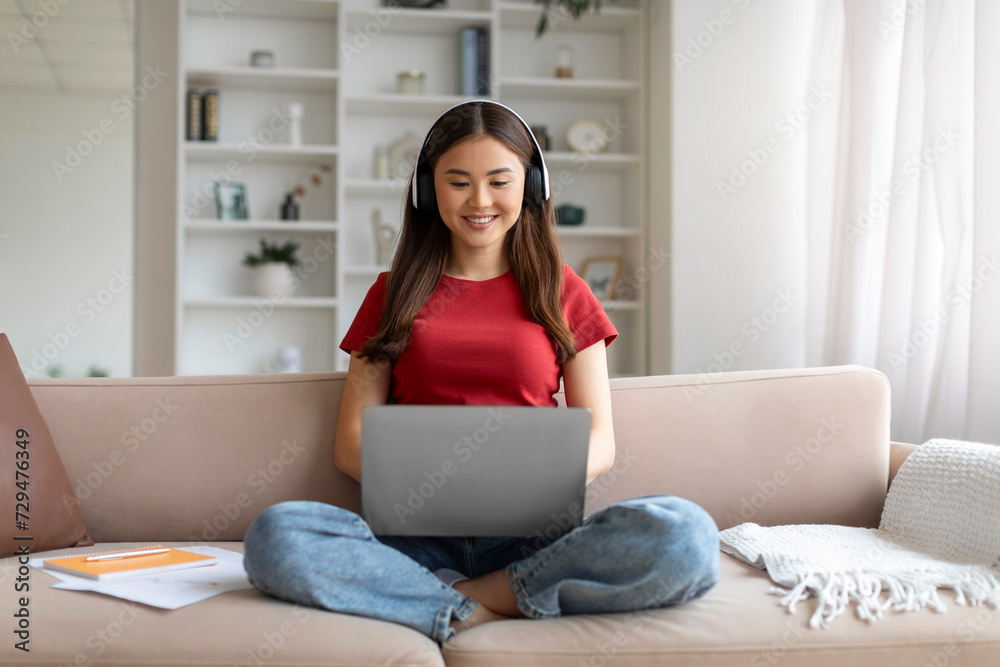Distance Learning. Young Asian Woman In Headphones Studying With Laptop At Home Distance Learning. Young Asian Woman In Headphones Studying With Laptop At Home